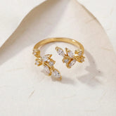 Gold ring with diamond accents on a light marble background