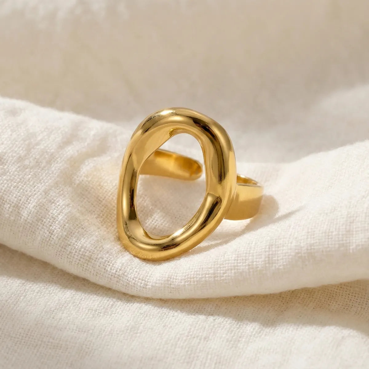 Oval statement golden ring on textured fabric