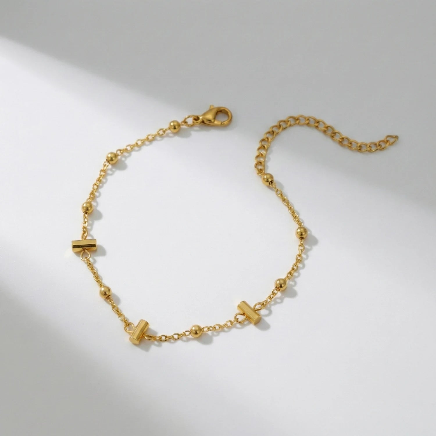 Gold bracelet with geometric links on a light gray background