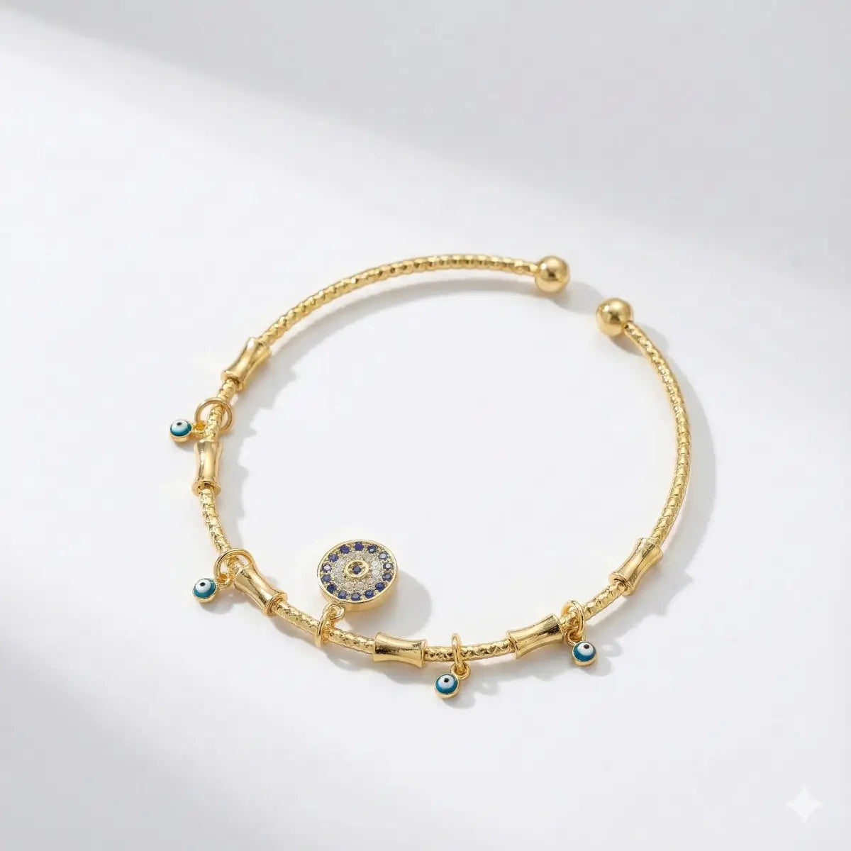 Gold bracelet with decorative elements on a light gray background