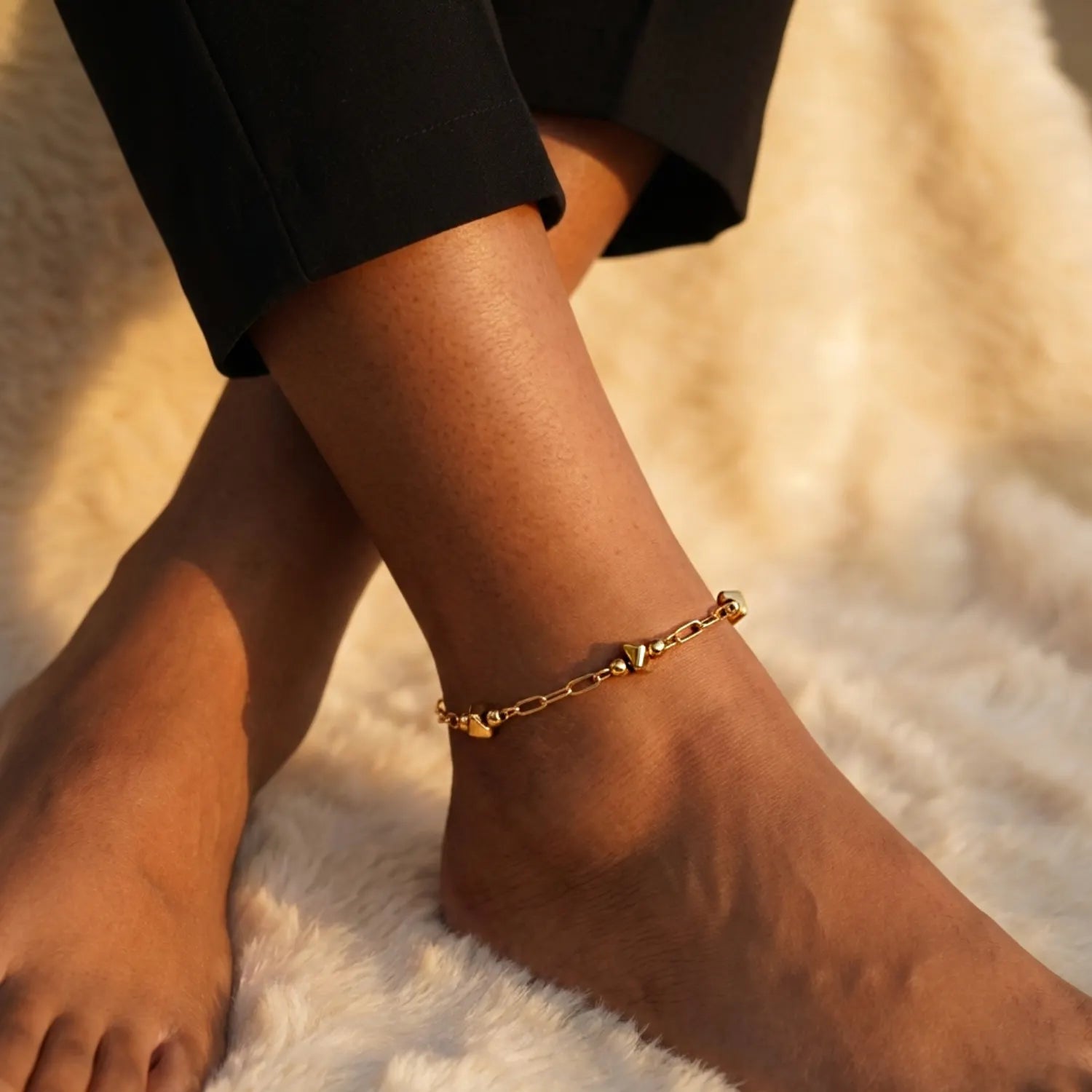 Gold anklet on a person's ankle with a blurred background