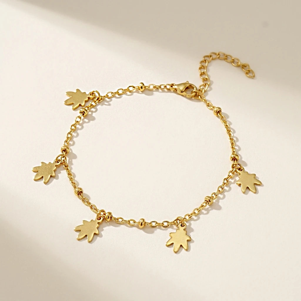 Gold bracelet with small star-shaped charms on a beige background