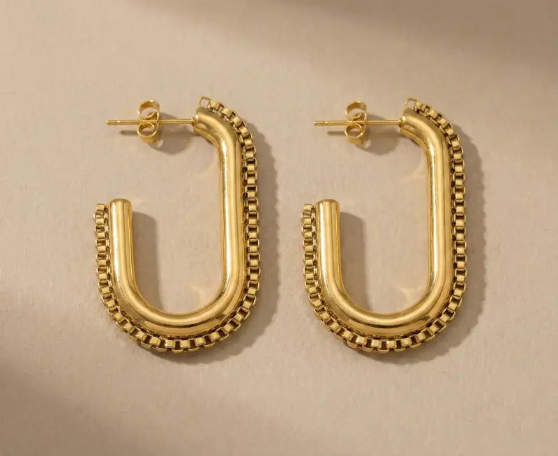 Golden geometric chain hoop earrings flat lay