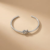 Silver knot bangle on a beige background