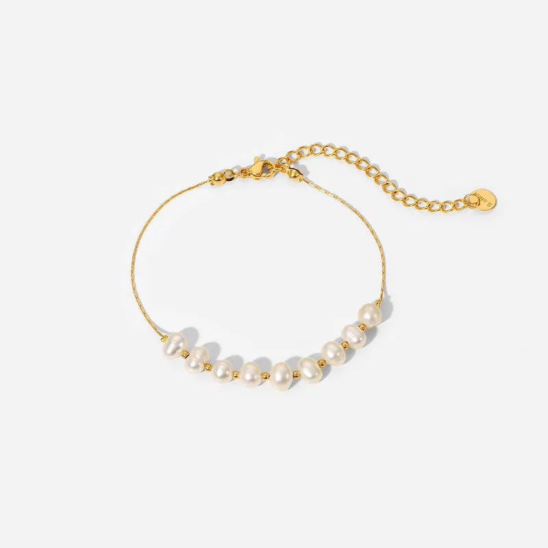 Gold bracelet with pearls on a white background