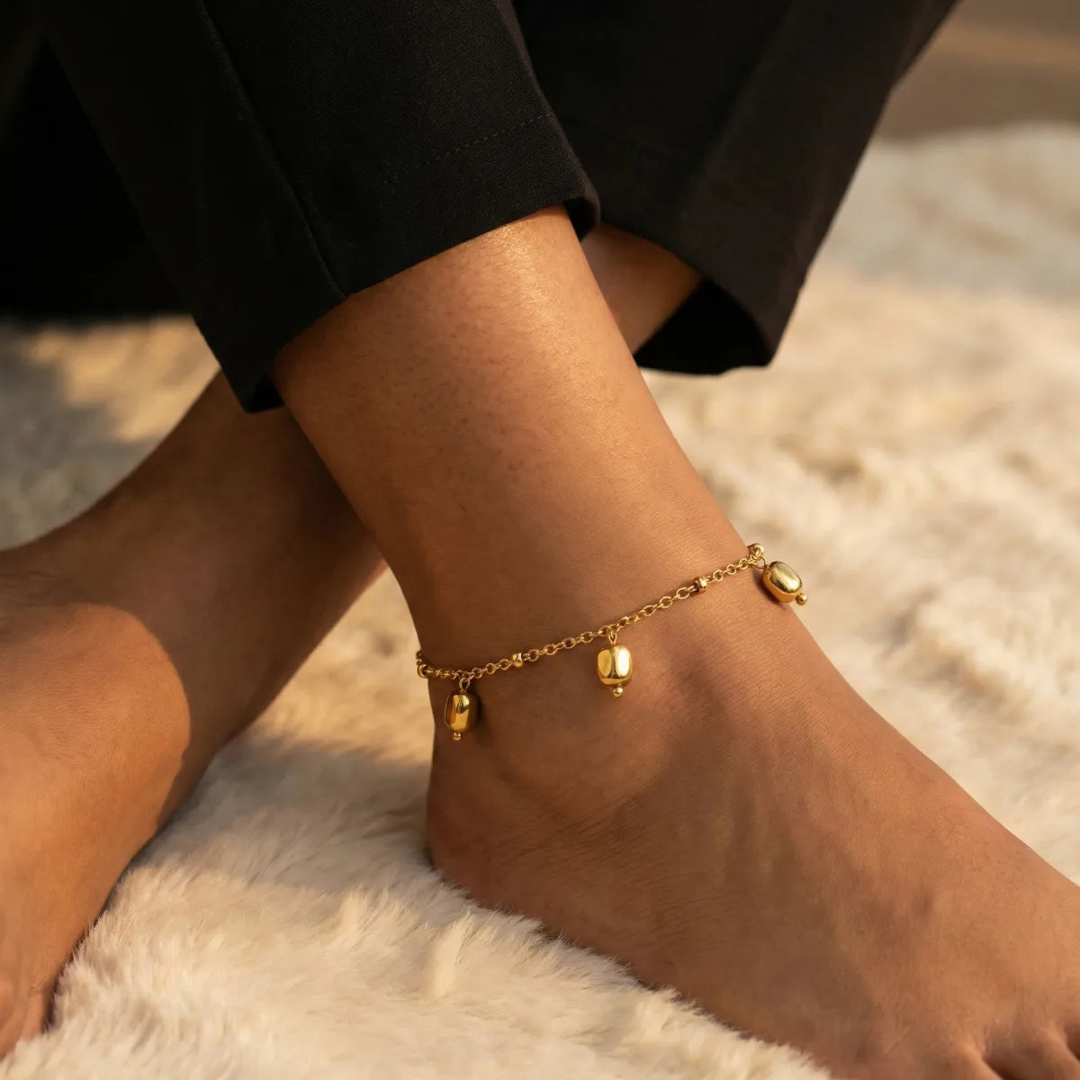Gold anklet on a foot with a blurred background