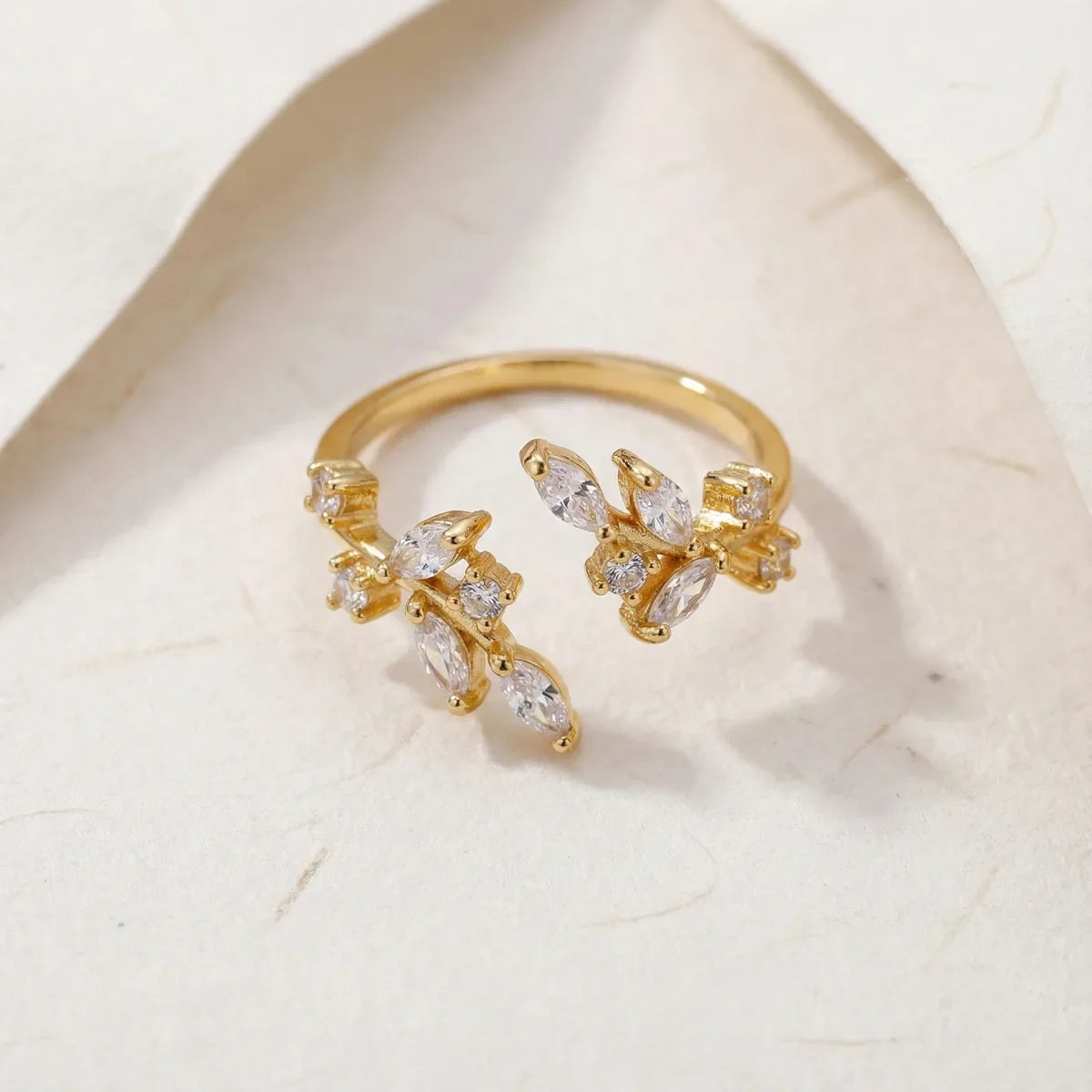 Gold ring with diamond accents on a light marble background