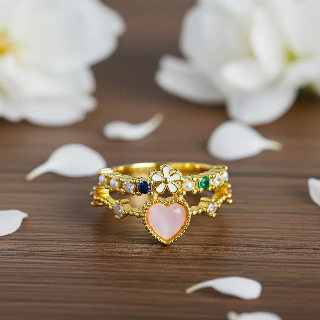 Gold ring with heart design on a wooden surface with white flowers in the background