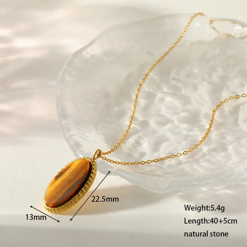 Gold necklace with a natural stone pendant on a white background