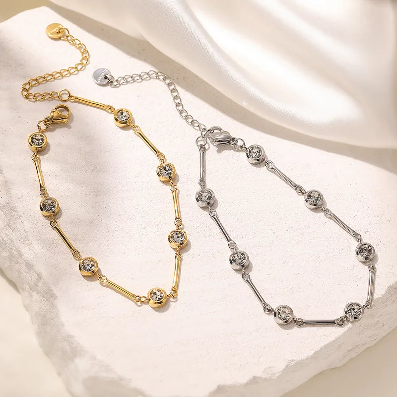 Two gold and silver bracelets on a textured white surface