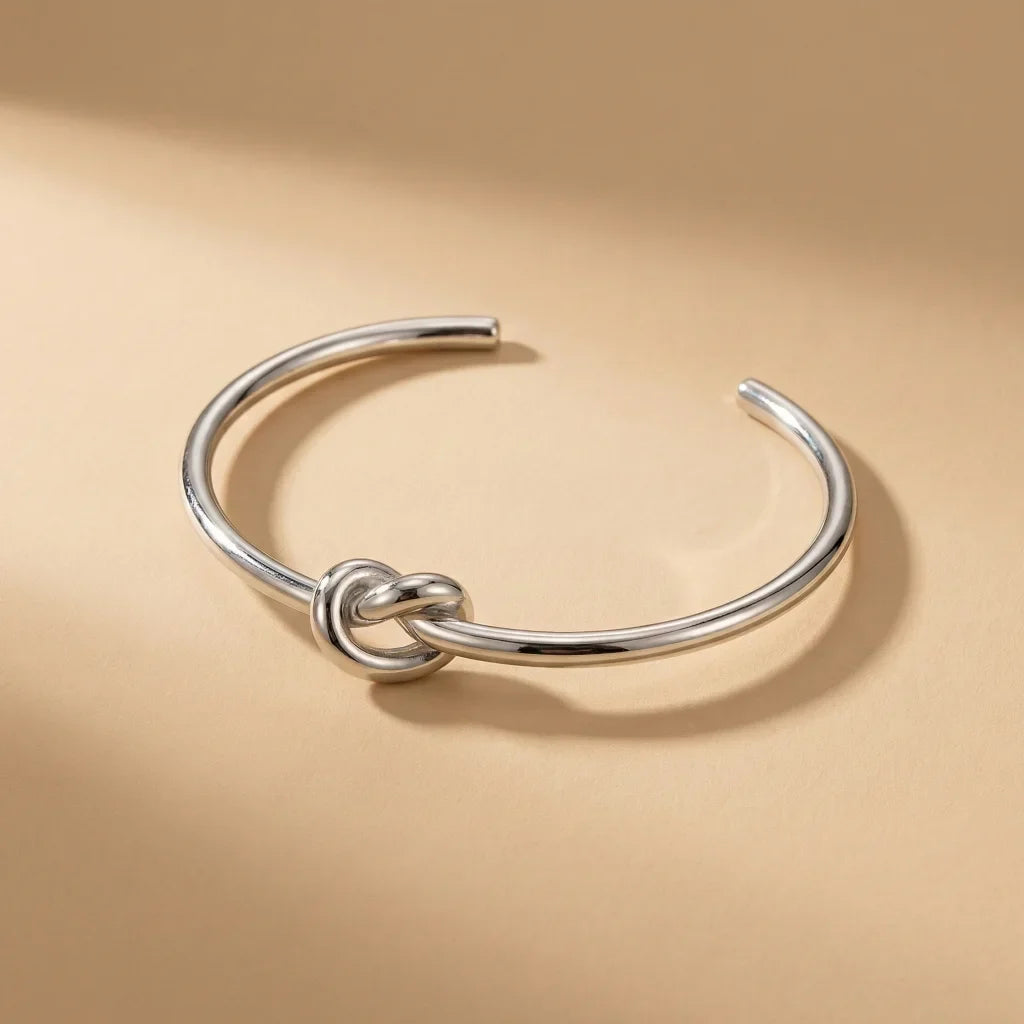 Silver knot bangle on a beige background