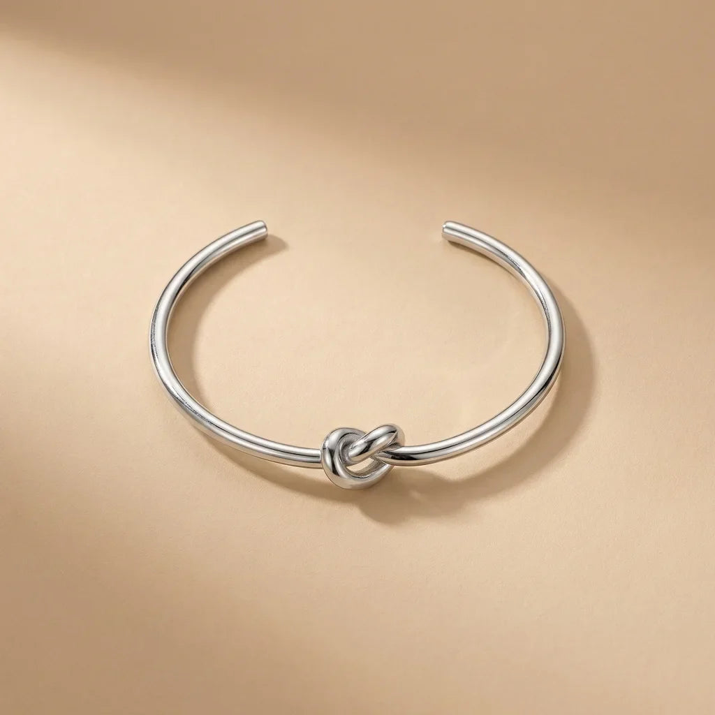 Silver knot bangle on a beige background