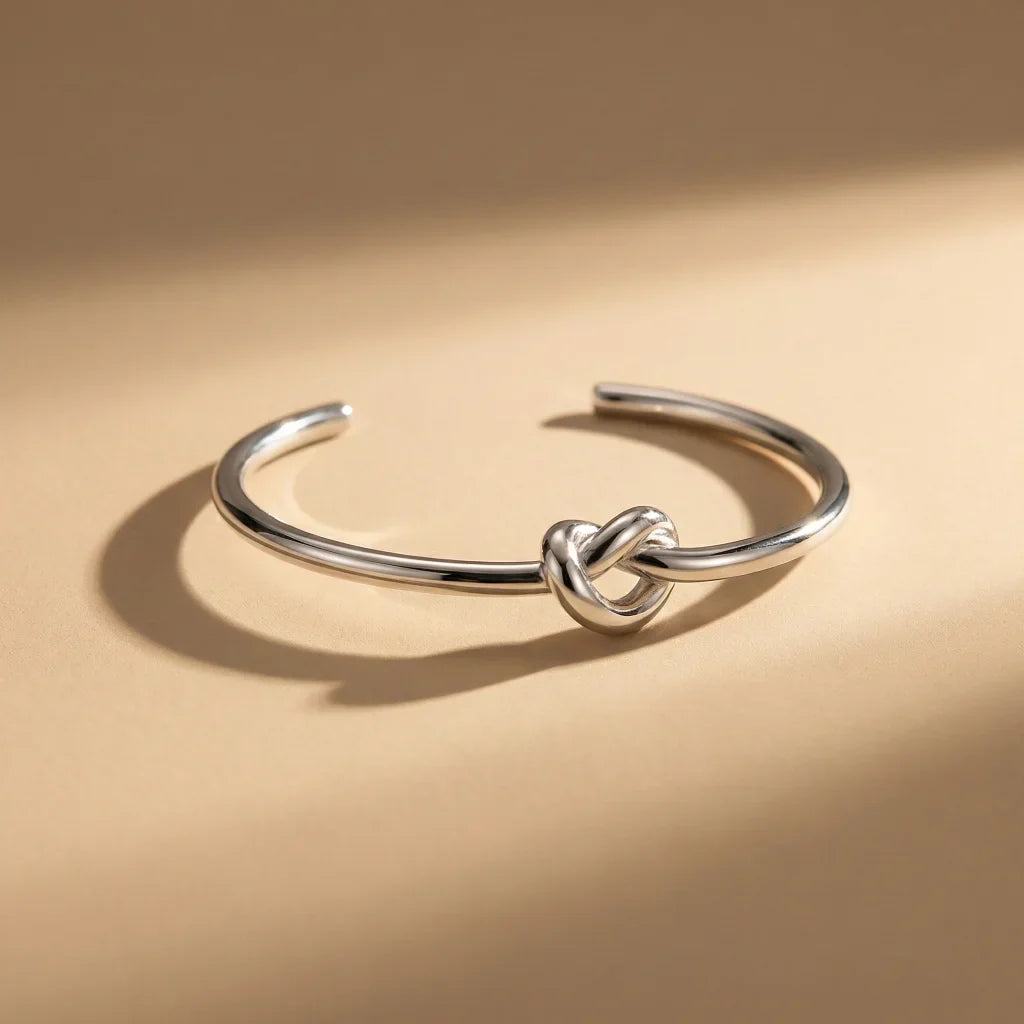 Silver knot bracelet on a beige background