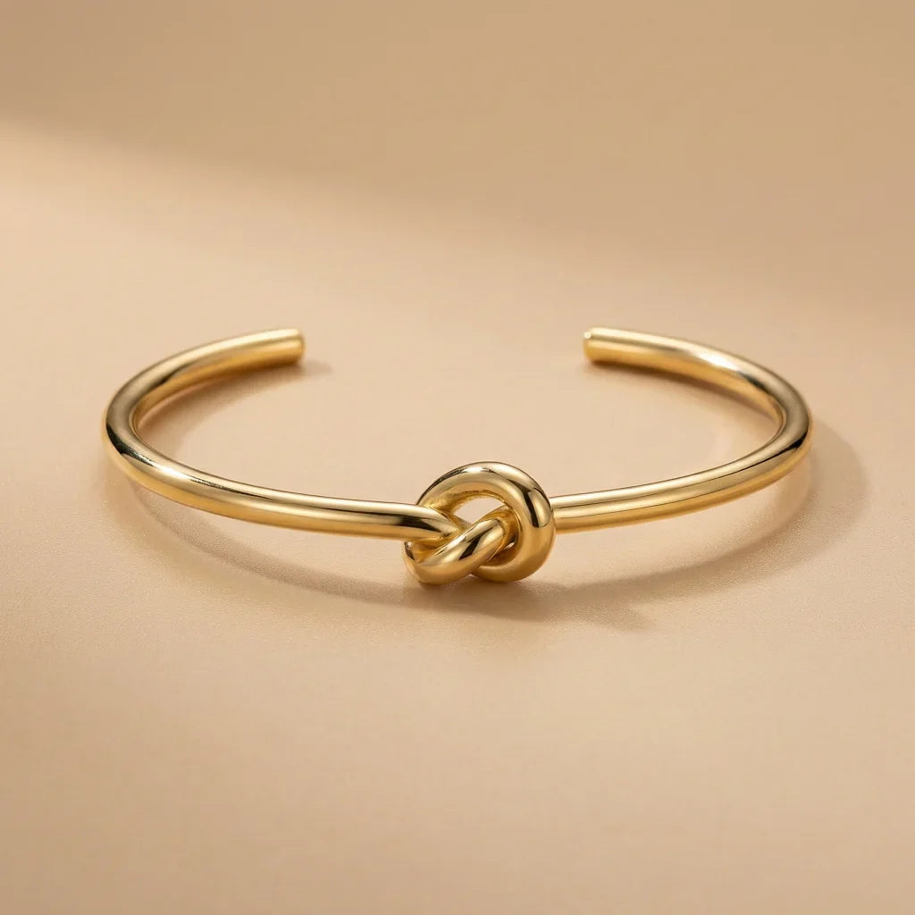 Gold knot bracelet on a beige background