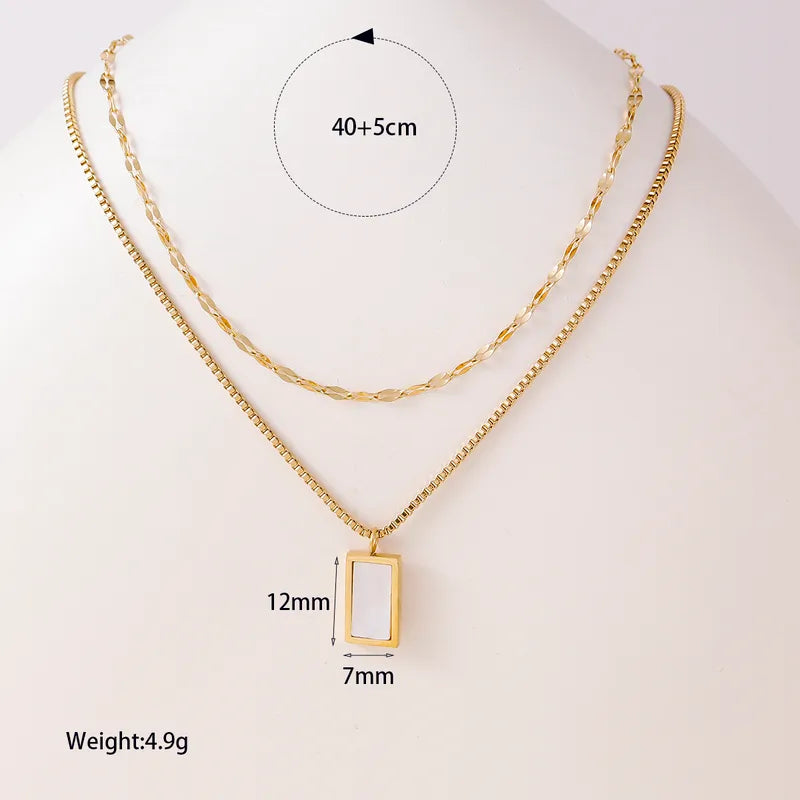 Gold necklace with a pendant, showing measurements on a white background