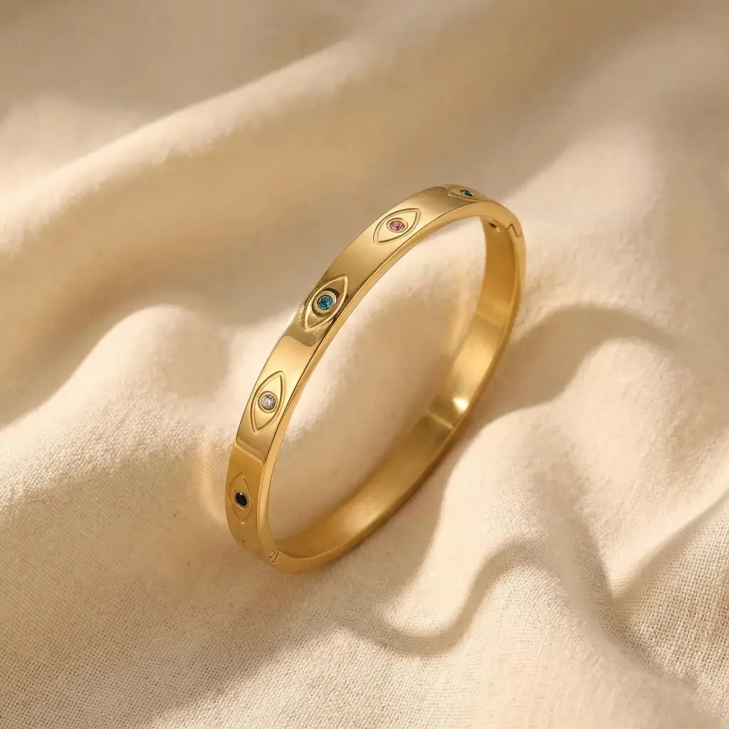 Gold ring with embedded gemstones on a beige fabric background