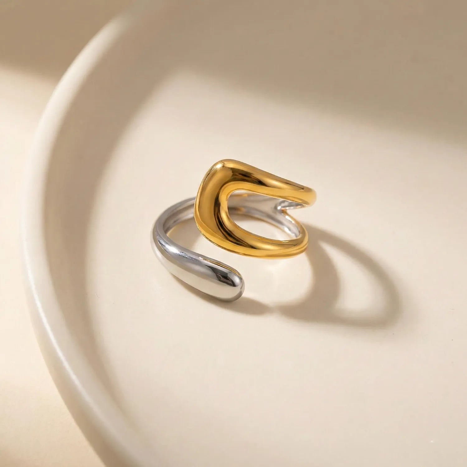 Gold and silver ring on a beige background