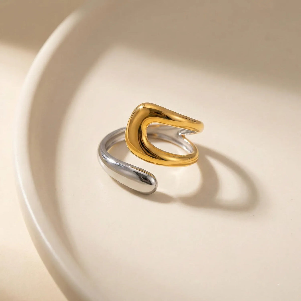 Gold and silver ring on a beige background